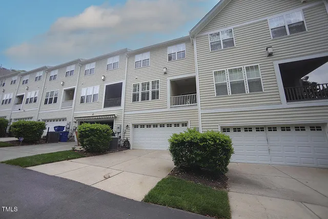 a front view of a house with garden and plants