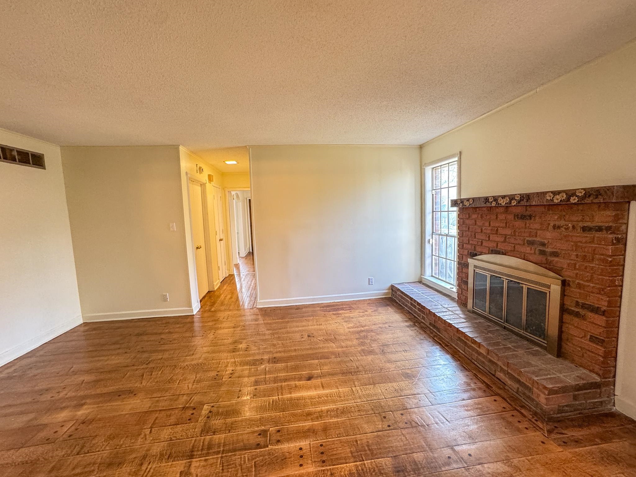 1345 Hickory Ridge Cove Memphis, TN 38116 - Photo 12 of 26 a view of empty room with wooden floor and fireplace