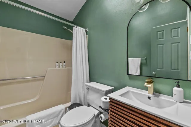 a view of a hallway with a chair and wooden floor
