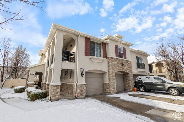 1235 West Spencer Road Pleasant Grove, UT 84062 - Photo 1 of 1 View of property featuring stucco siding, stone siding, a garage, and a balcony