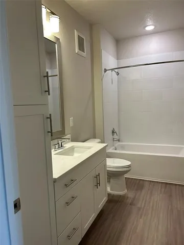 a bathroom with a double vanity sink toilet mirror and shower