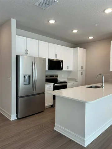 a kitchen with stainless steel appliances a refrigerator stove microwave and sink