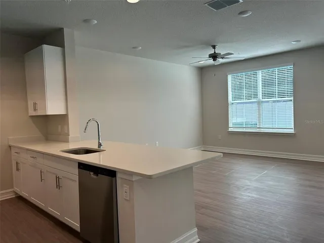 a kitchen with a sink cabinets and wooden floor