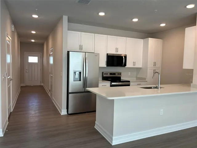 a kitchen with stainless steel appliances a refrigerator microwave and sink