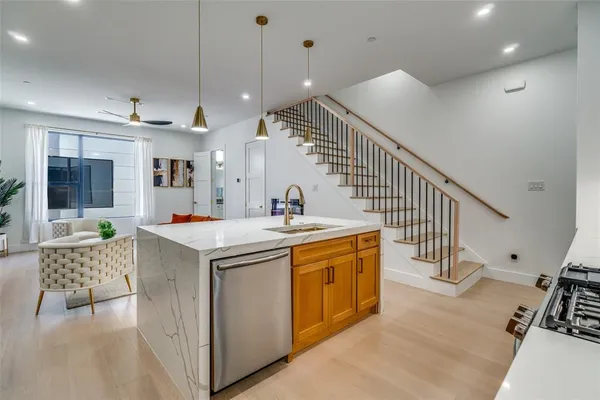 a kitchen with stainless steel appliances granite countertop a sink a stove and a refrigerator