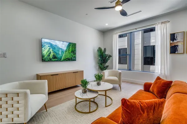 a living room with furniture kitchen view and a chandelier
