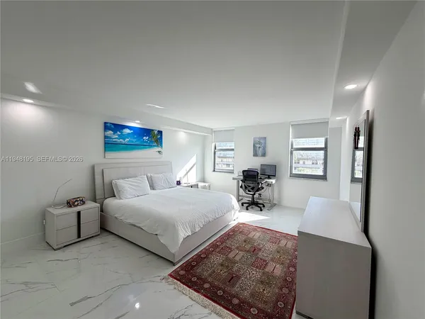 a bedroom with bed couches and white walls