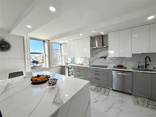 a kitchen with stainless steel appliances granite countertop a sink dishwasher stove and white cabinets