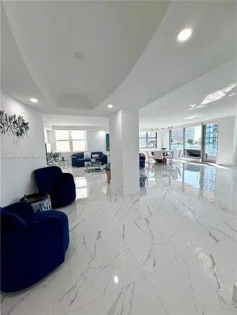 a living room with furniture and a view of kitchen