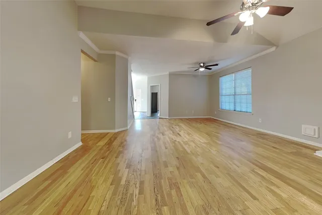 a view of empty room with wooden floor
