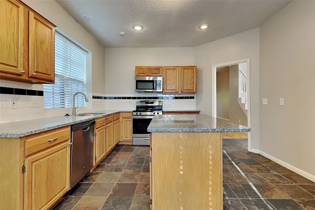 a kitchen with stainless steel appliances granite countertop a stove a sink and a microwave
