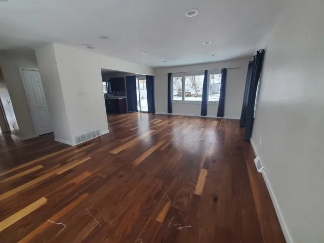wooden floor in an empty room with a window