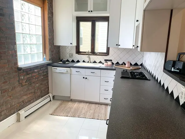 a kitchen with a sink a stove and cabinets