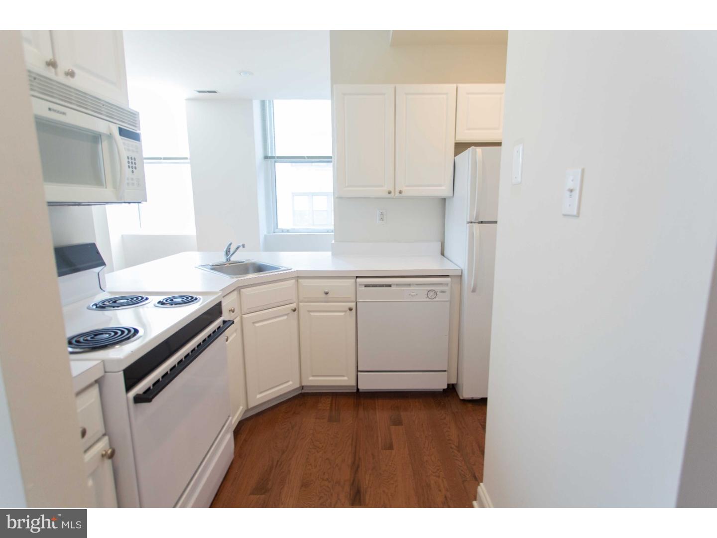 1600-4 Walnut Street, Unit 1003 Philadelphia, PA 19103 - Photo 12 of 25 a kitchen with a sink stove and white cabinets