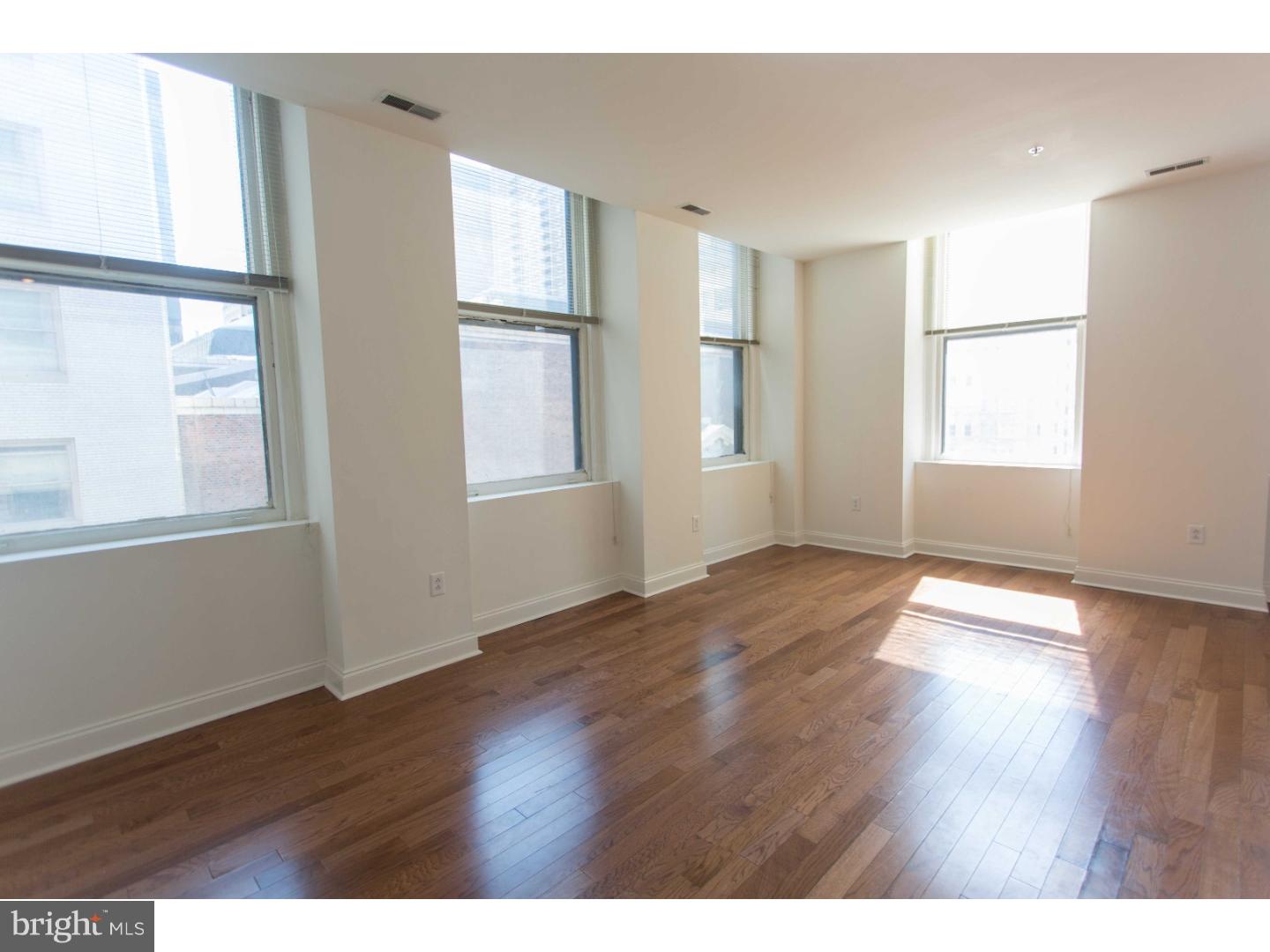 1600-4 Walnut Street, Unit 1003 Philadelphia, PA 19103 - Photo 9 of 25 a view of an empty room with wooden floor and a window
