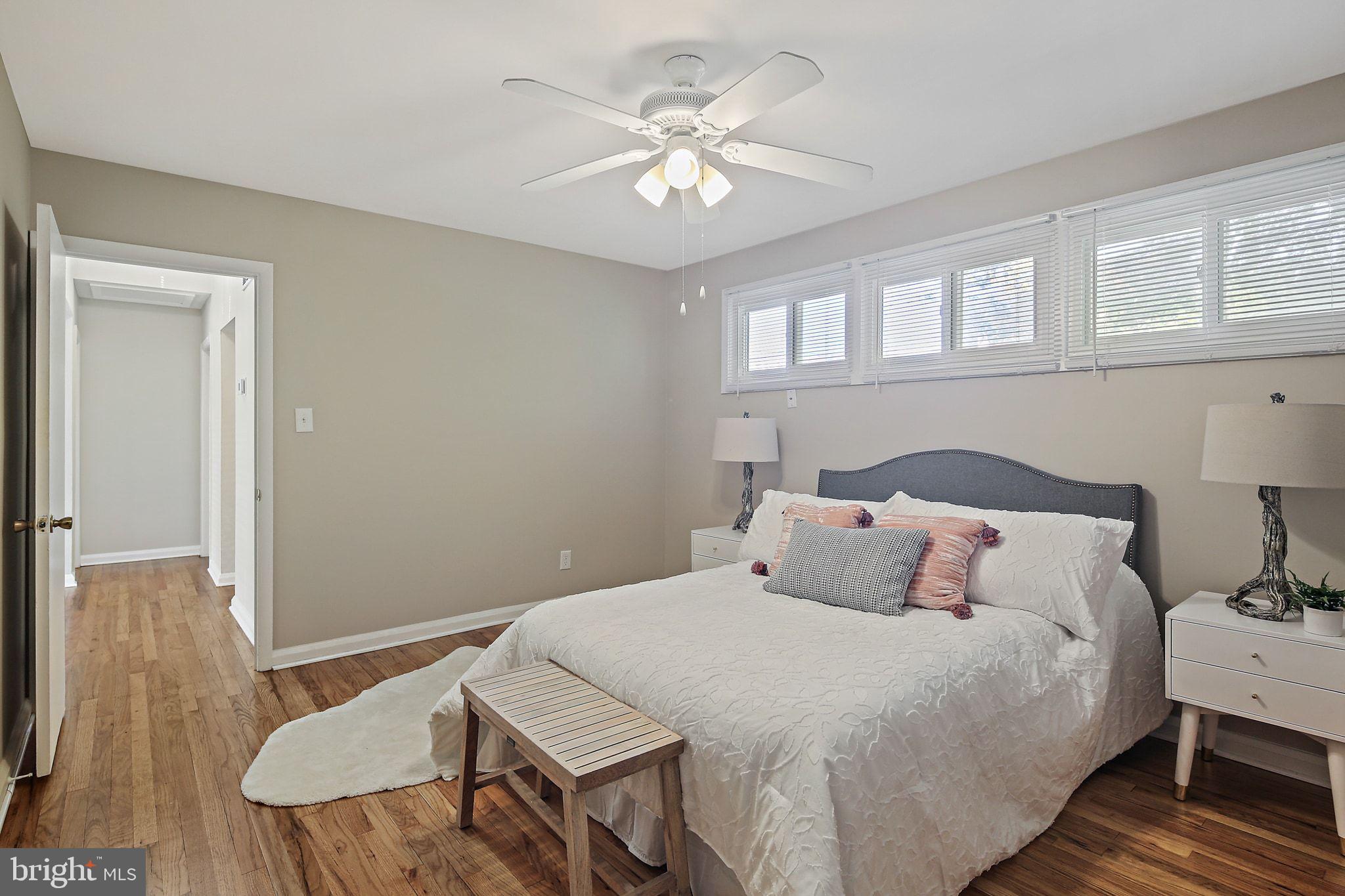 6204 Scranton Road Baltimore, MD 21237 - Photo 13 of 31 a bedroom with a bed and a table with wooden floor