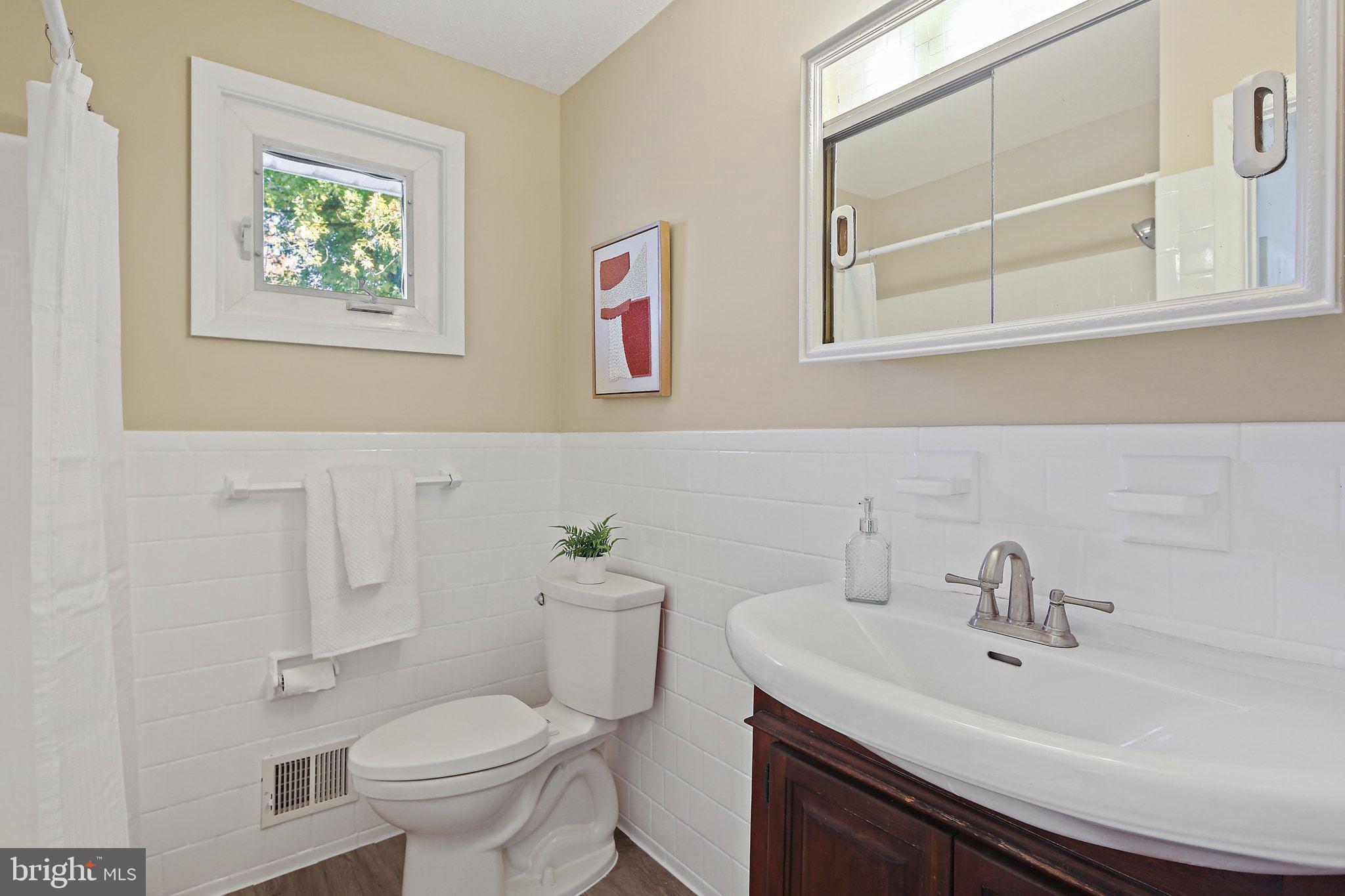 6204 Scranton Road Baltimore, MD 21237 - Photo 19 of 31 a bathroom with a toilet a sink and mirror