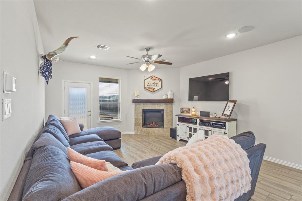 551 Ruthye Lane Pilot Point, TX 76258 - Photo 12 of 40 a living room with furniture a fireplace and a flat screen tv