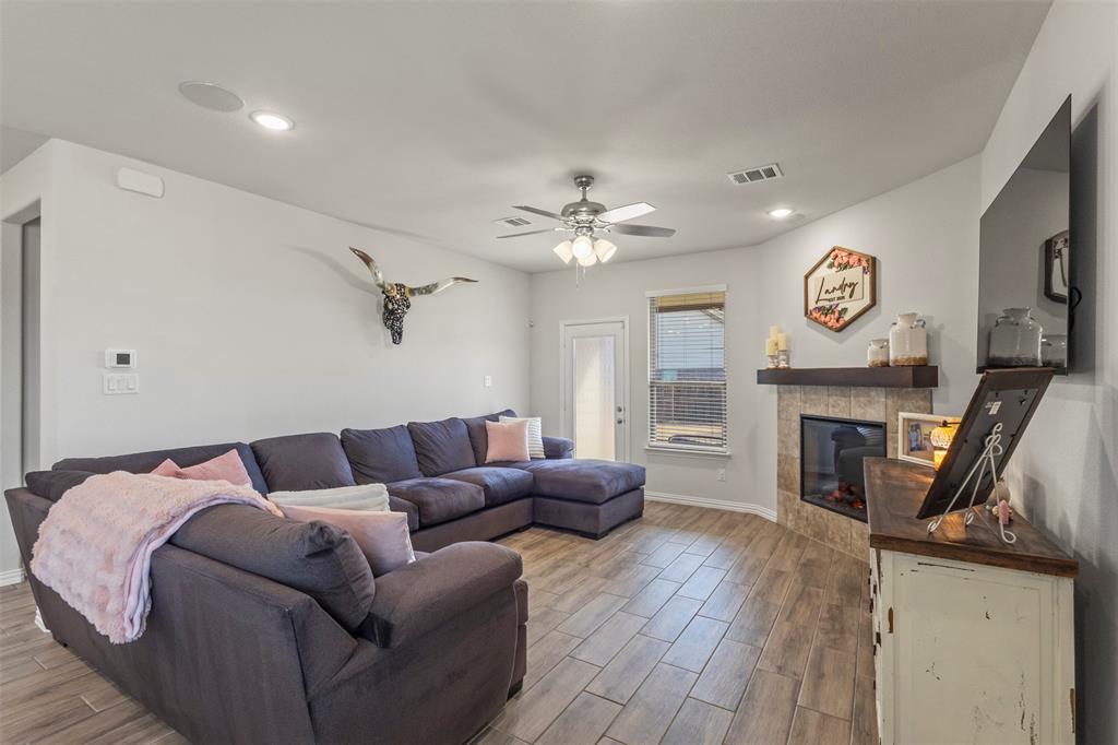 551 Ruthye Lane Pilot Point, TX 76258 - Photo 13 of 40 a living room with furniture a fireplace and a flat screen tv