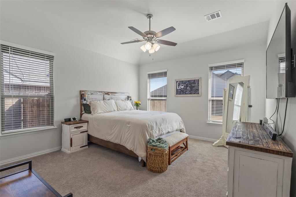 551 Ruthye Lane Pilot Point, TX 76258 - Photo 16 of 40 a spacious bedroom with a large bed and a chandelier