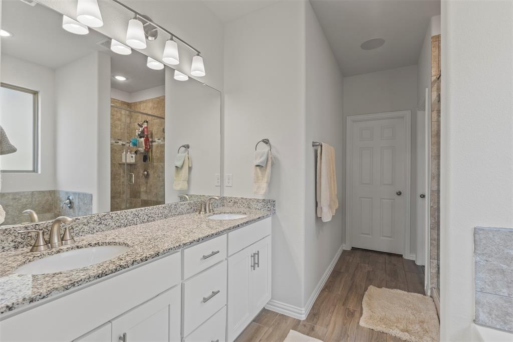551 Ruthye Lane Pilot Point, TX 76258 - Photo 19 of 40 a spacious bathroom with a granite countertop sink a mirror and a shower
