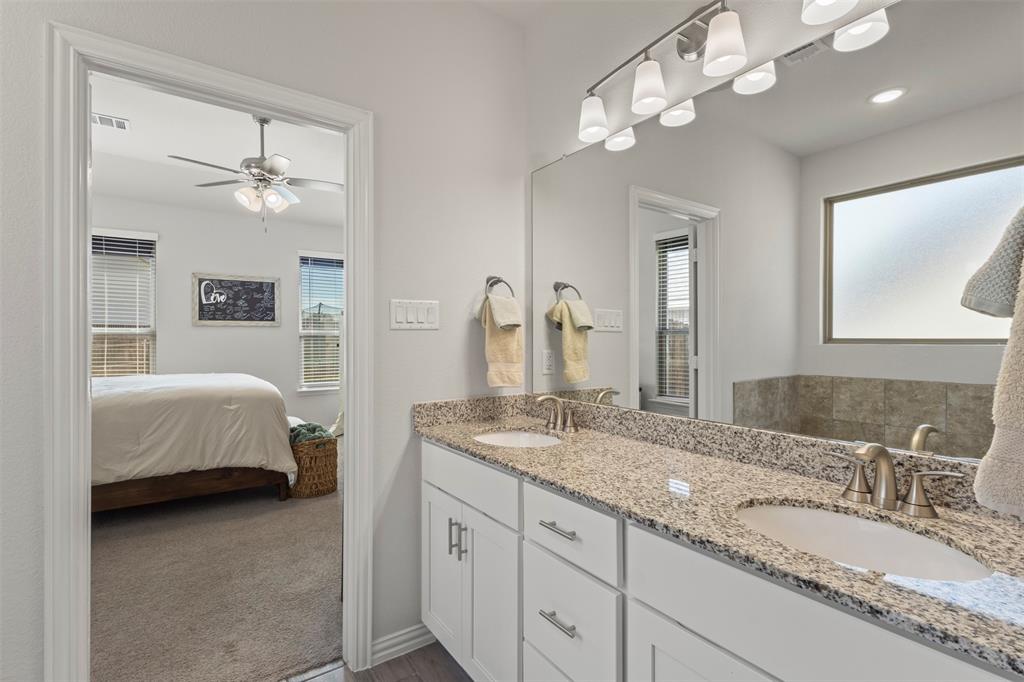 551 Ruthye Lane Pilot Point, TX 76258 - Photo 20 of 40 a en suite bathroom with double vanity sinks a vanity a lamp and a mirror
