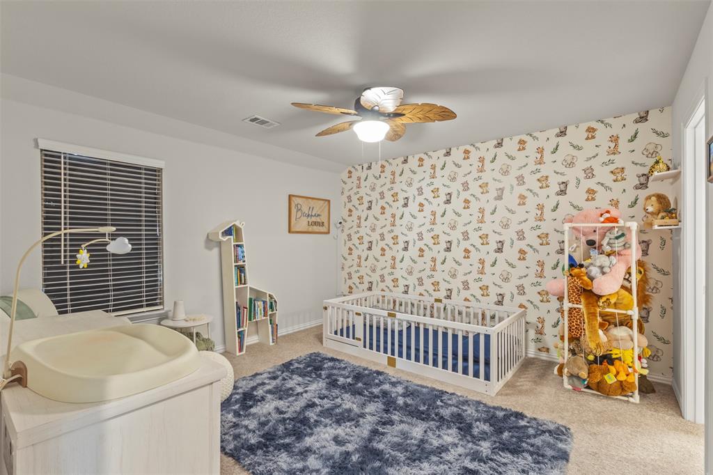 551 Ruthye Lane Pilot Point, TX 76258 - Photo 23 of 40 a bedroom with a bed and a chandelier
