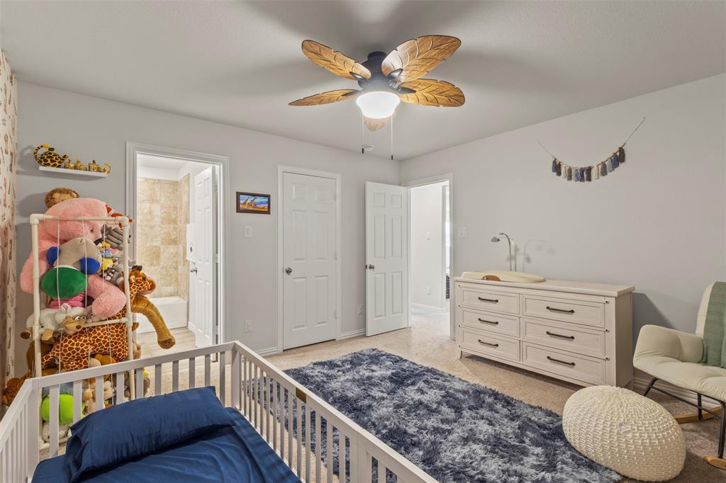 551 Ruthye Lane Pilot Point, TX 76258 - Photo 24 of 40 a bedroom with a bed and a chandelier