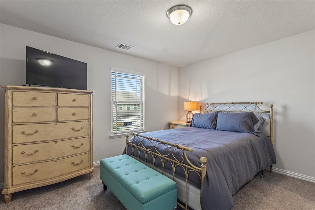 551 Ruthye Lane Pilot Point, TX 76258 - Photo 26 of 40 a bedroom with a bed and flat screen tv