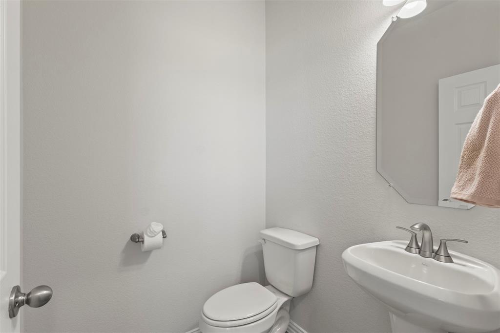 551 Ruthye Lane Pilot Point, TX 76258 - Photo 6 of 40 a bathroom with a toilet a sink and mirror