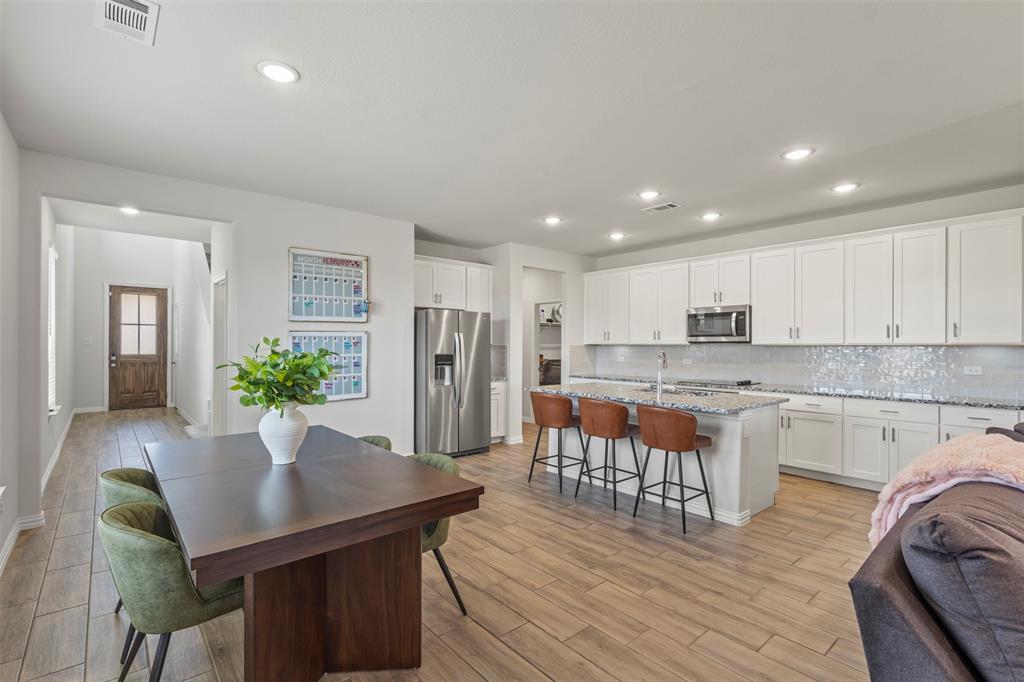 551 Ruthye Lane Pilot Point, TX 76258 - Photo 7 of 40 a living room with stainless steel appliances kitchen island granite countertop furniture and wooden floor