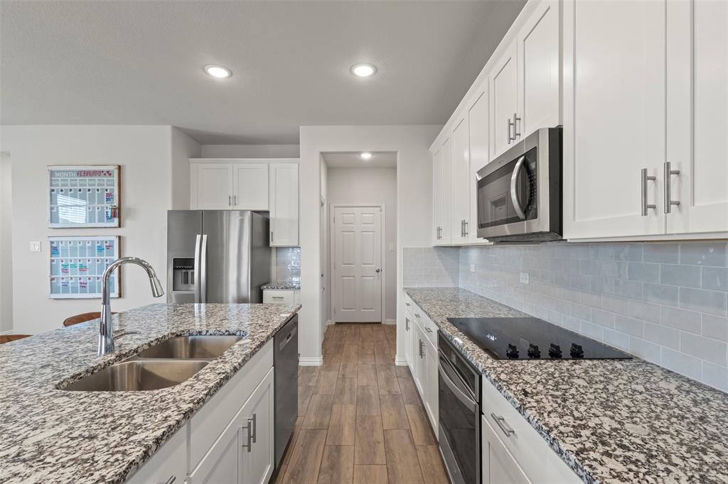 551 Ruthye Lane Pilot Point, TX 76258 - Photo 9 of 40 a kitchen with stainless steel appliances granite countertop a sink stove and refrigerator