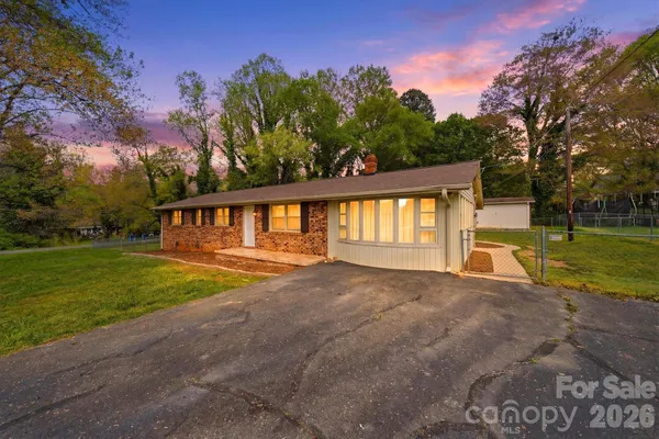 a view of an house with backyard and a tree