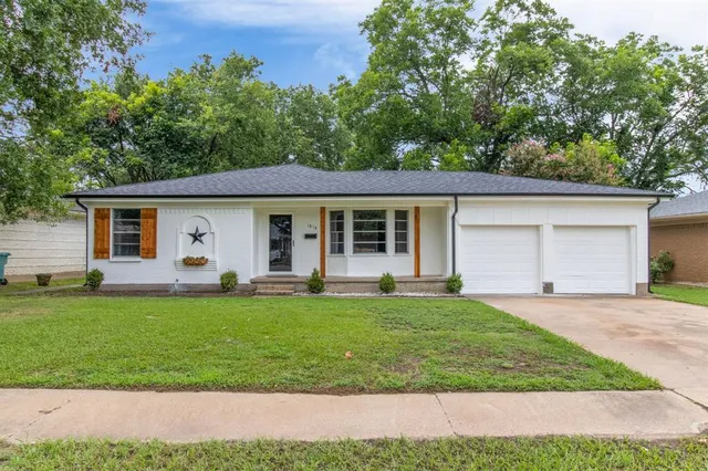 a front view of a house with a garden and yard
