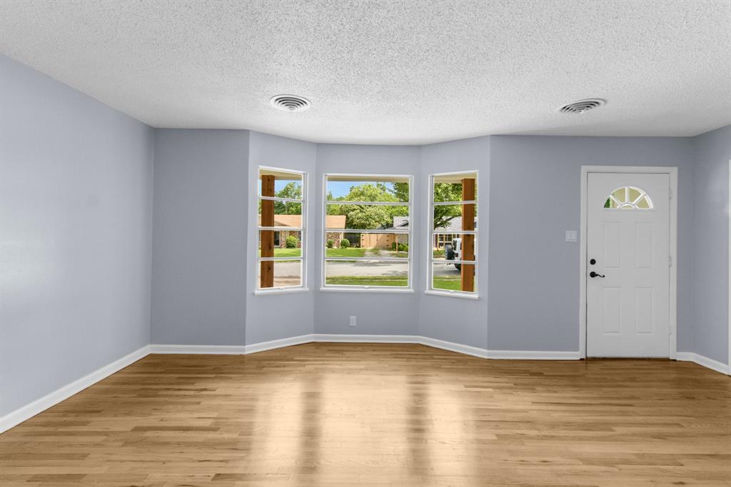 1818 Belden Street Sherman, TX 75092 - Photo 12 of 28 a view of an empty room with wooden floor and a window