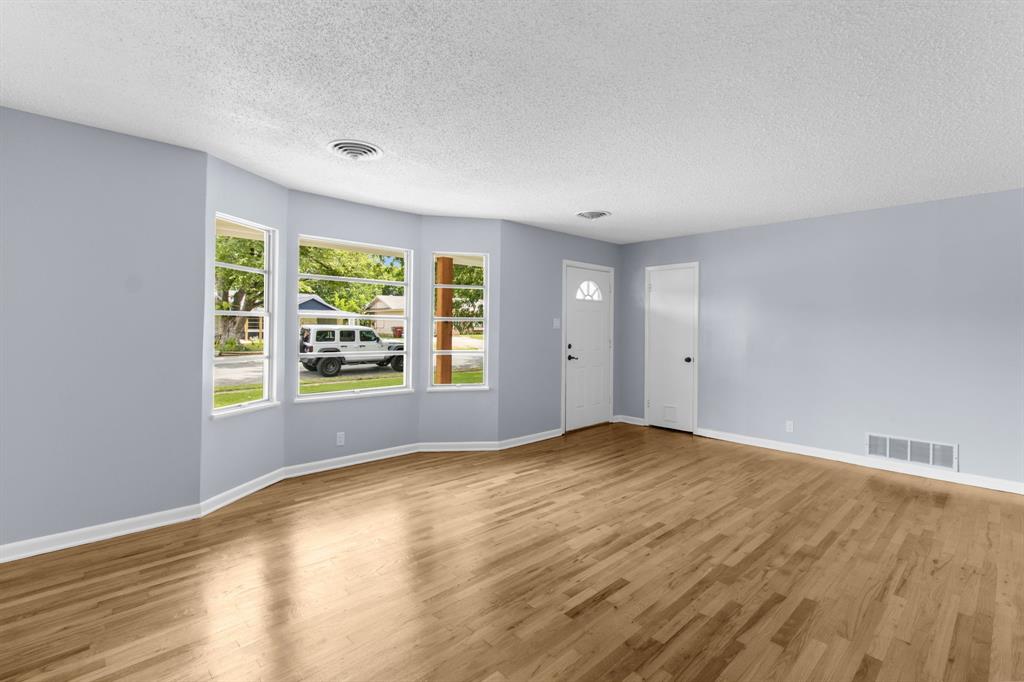 1818 Belden Street Sherman, TX 75092 - Photo 13 of 28 wooden floor in an empty room with a window