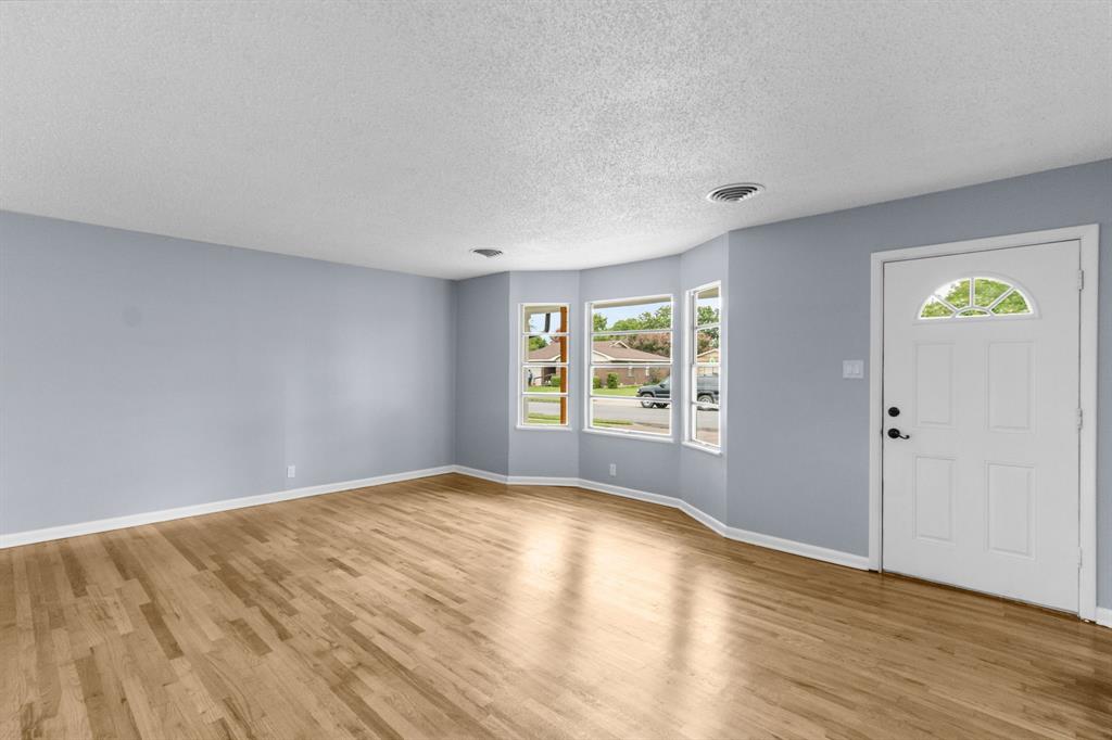 1818 Belden Street Sherman, TX 75092 - Photo 15 of 28 a view of an empty room with wooden floor and a window
