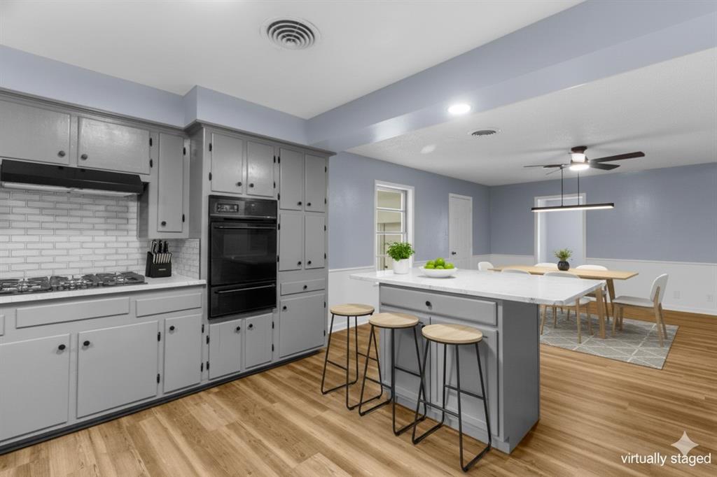 1818 Belden Street Sherman, TX 75092 - Photo 2 of 28 a kitchen with stainless steel appliances kitchen island granite countertop a table chairs and a refrigerator