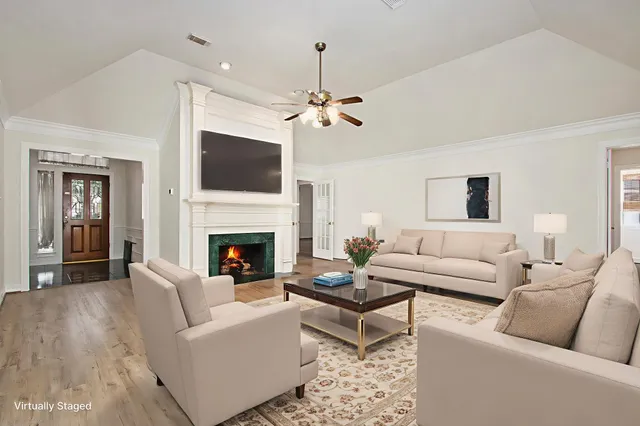a living room with furniture a flat screen tv and a fireplace