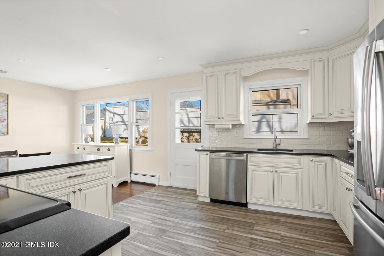 29 Thorn Hill Road Riverside, CT 06878 - Photo 8 of 24 a kitchen with stainless steel appliances granite countertop a stove a sink dishwasher and white cabinets with wooden floor
