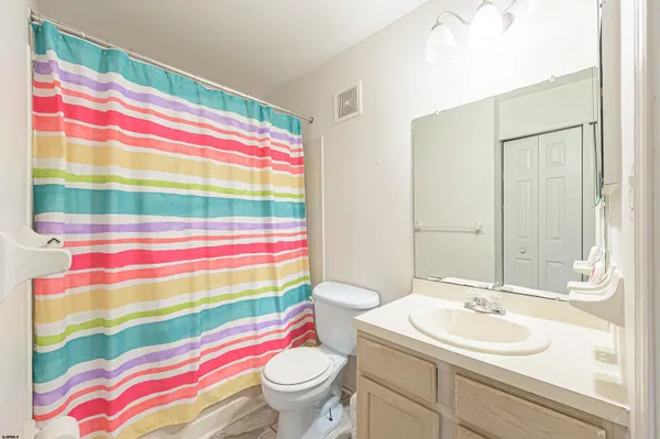 a bathroom with a sink toilet and shower curtain
