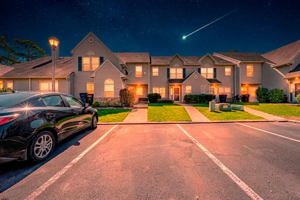 a view of yard with car parked in front of house
