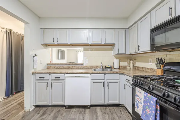 a kitchen with granite countertop a sink stove and refrigerator