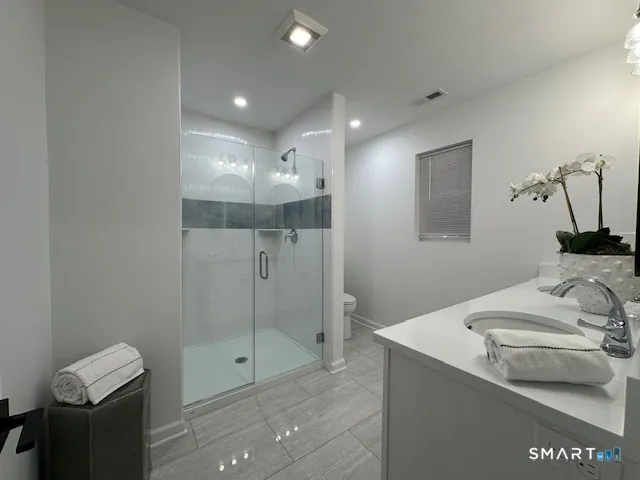 a bathroom with a shower sink and mirror