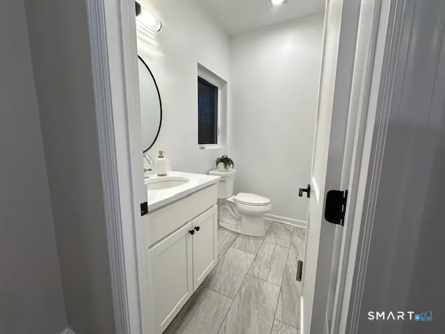 a bathroom with a sink a toilet and a mirror