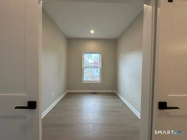 a kitchen with stainless steel appliances kitchen island granite countertop a stove top oven a sink dishwasher a refrigerator and a dining table with wooden floor