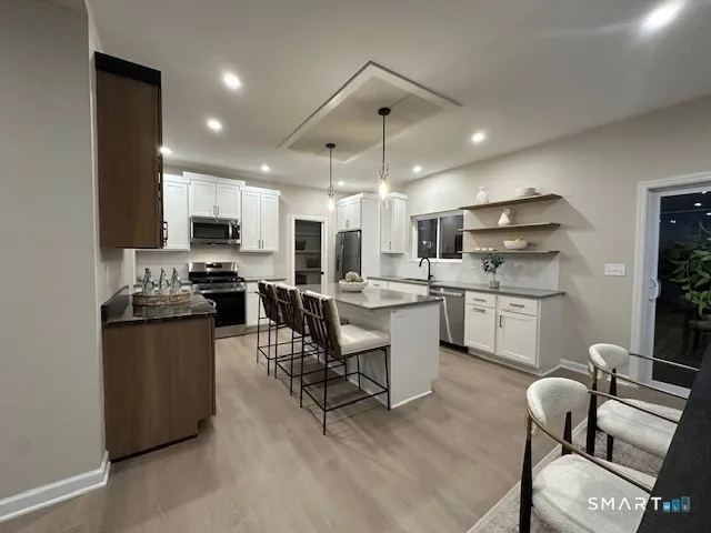 a kitchen with a sink a counter top space appliances and cabinets