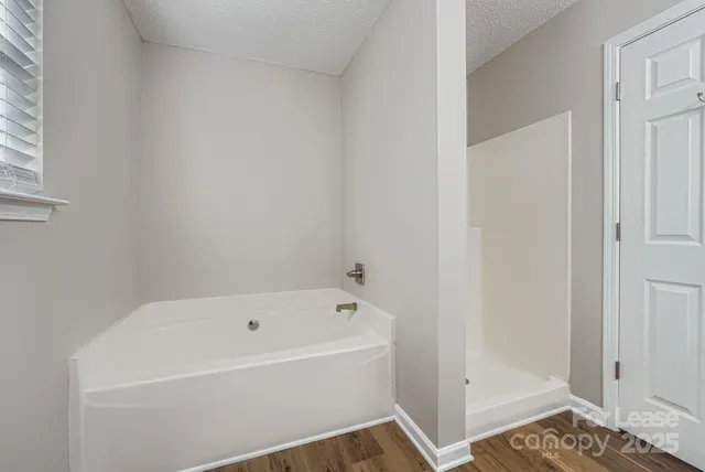 a white bath tub sitting next to a shower