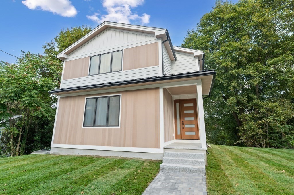 863 Main Street Reading, MA 01867 - Photo 1 of 42 a front view of a house with a yard and trees