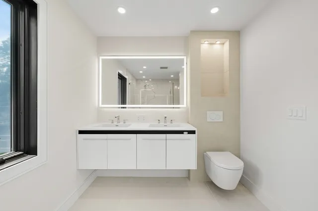 a bathroom with a toilet sink and mirror